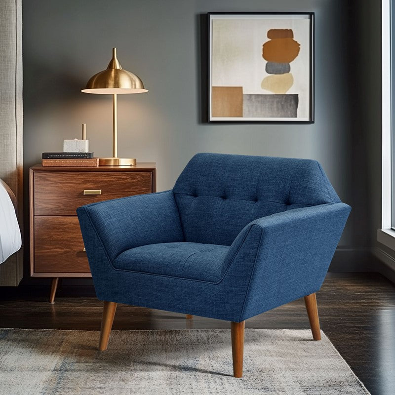 Blue armchair in a room with a wooden side table and abstract art on the wall.
